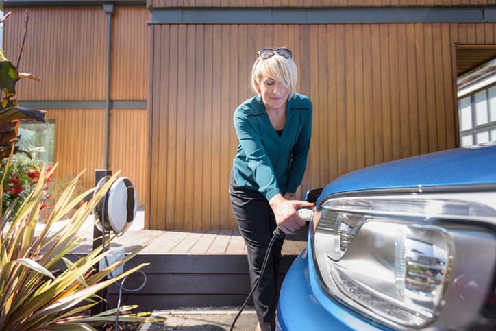 Woman charging electric car from charging station