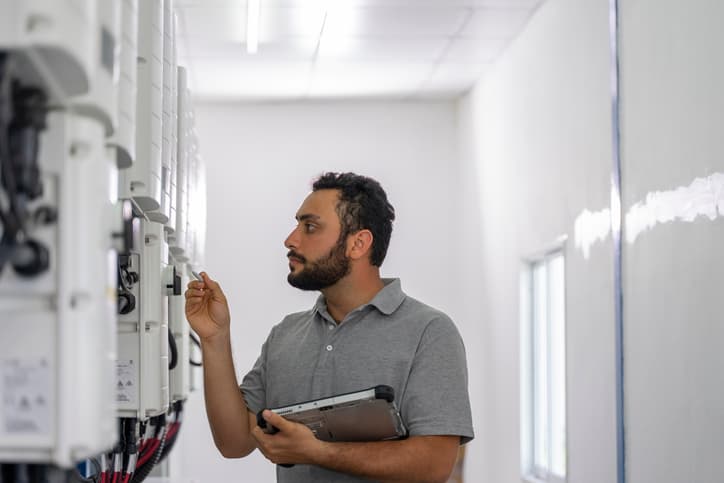 Technician inspecting solar batteries in a photovoltaic room