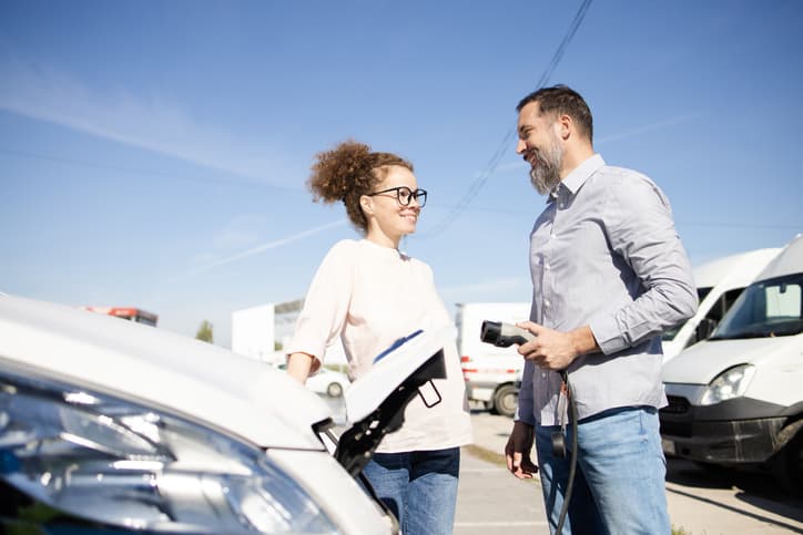 Couple charging their electric van at the charging station